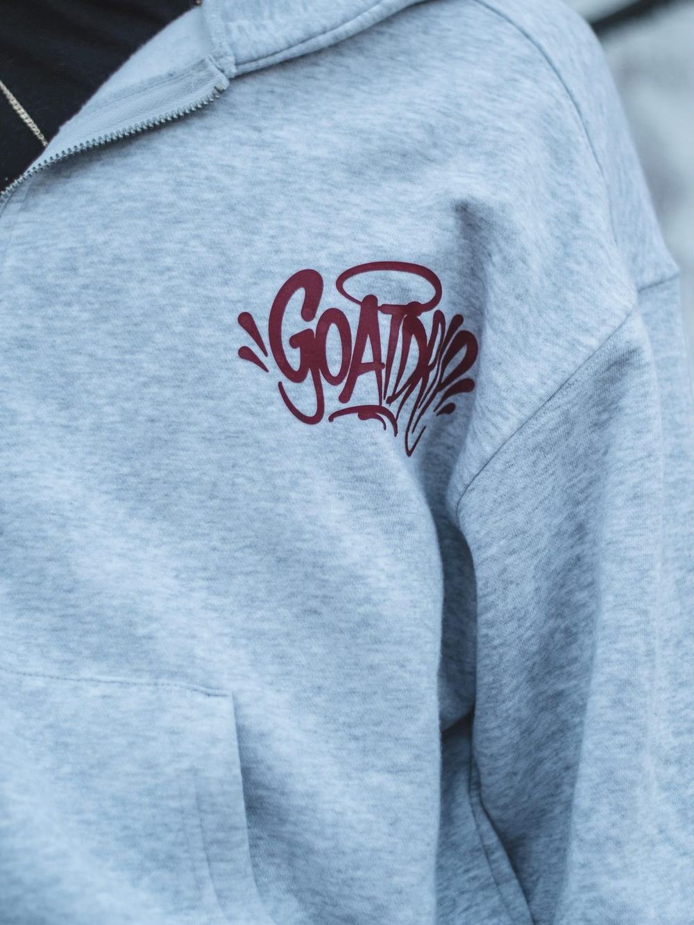 The GOATDRIP script logo printed on white fabric, up close